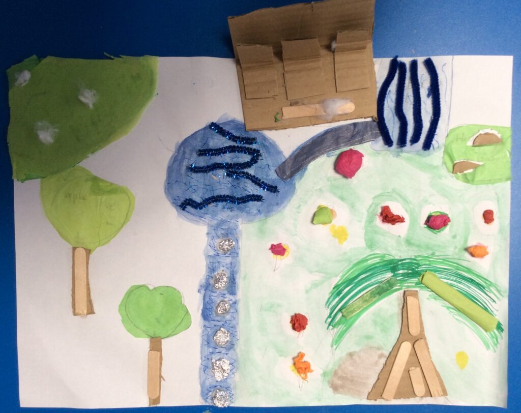 A 2D/3D mixed media piece using watercolour paint, pipe cleaners, silver paper, tissue paper, card, cotton wool and lolly sticks. Trees, grass and brightly coloured flowers surround two ponds connected by a bridge, with a river flowing into one pond. A bench provides seating near the pond.